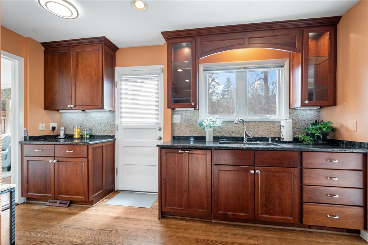 2440 Simpson Street Evanston, IL 60201 - Photo 12 of 34 a kitchen with granite countertop wooden cabinets and wooden floor