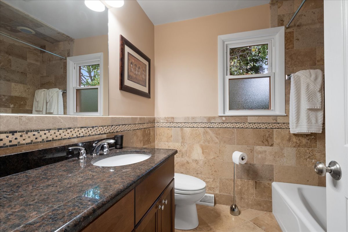 2440 Simpson Street Evanston, IL 60201 - Photo 25 of 34 a bathroom with a granite countertop sink and a mirror