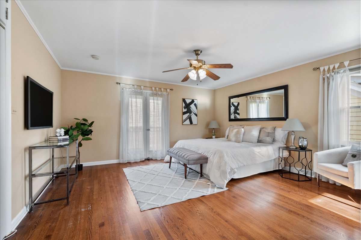 2440 Simpson Street Evanston, IL 60201 - Photo 28 of 34 a spacious bedroom with a bed wooden floor and a flat screen tv