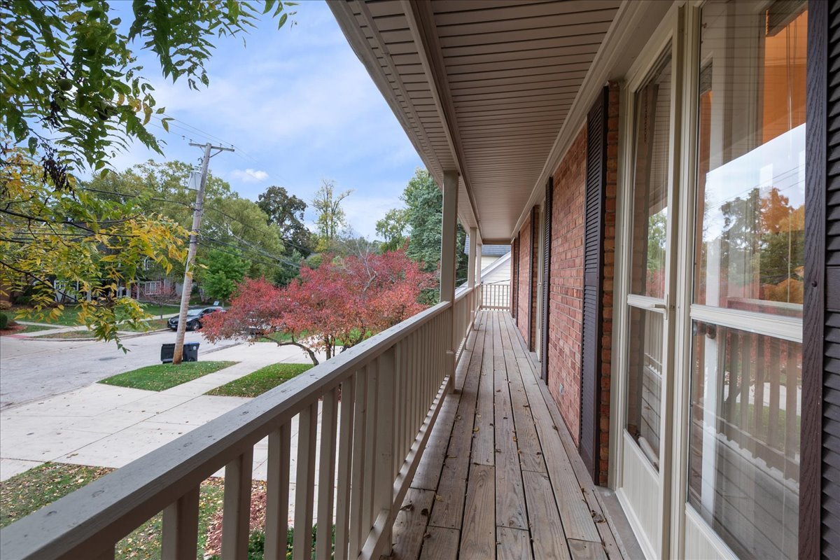 2440 Simpson Street Evanston, IL 60201 - Photo 30 of 34 a balcony with wooden floor and trees in the back