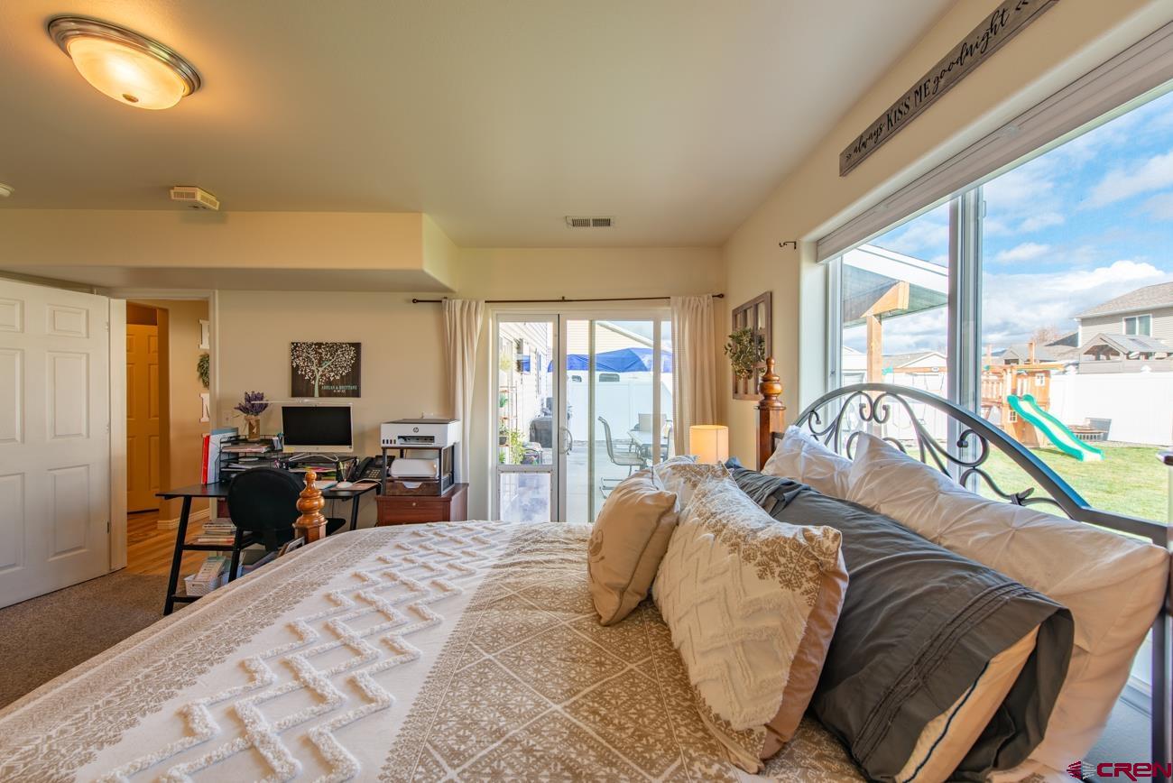 111 6675th Road Montrose, CO 81401 - Photo 17 of 40 a bedroom with a bed and a large window with the outer view