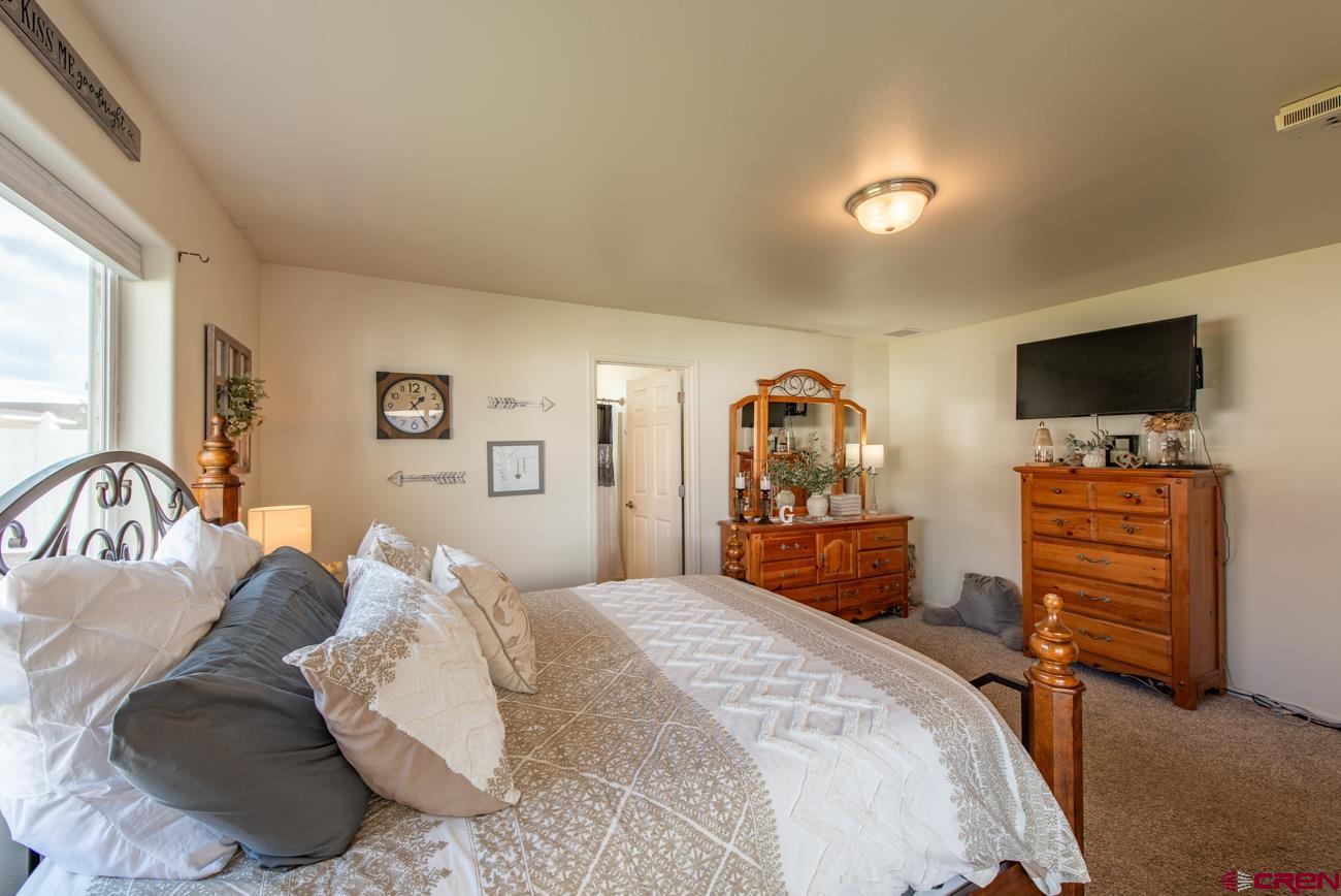 111 6675th Road Montrose, CO 81401 - Photo 19 of 40 a bedroom with a bed and a flat screen tv