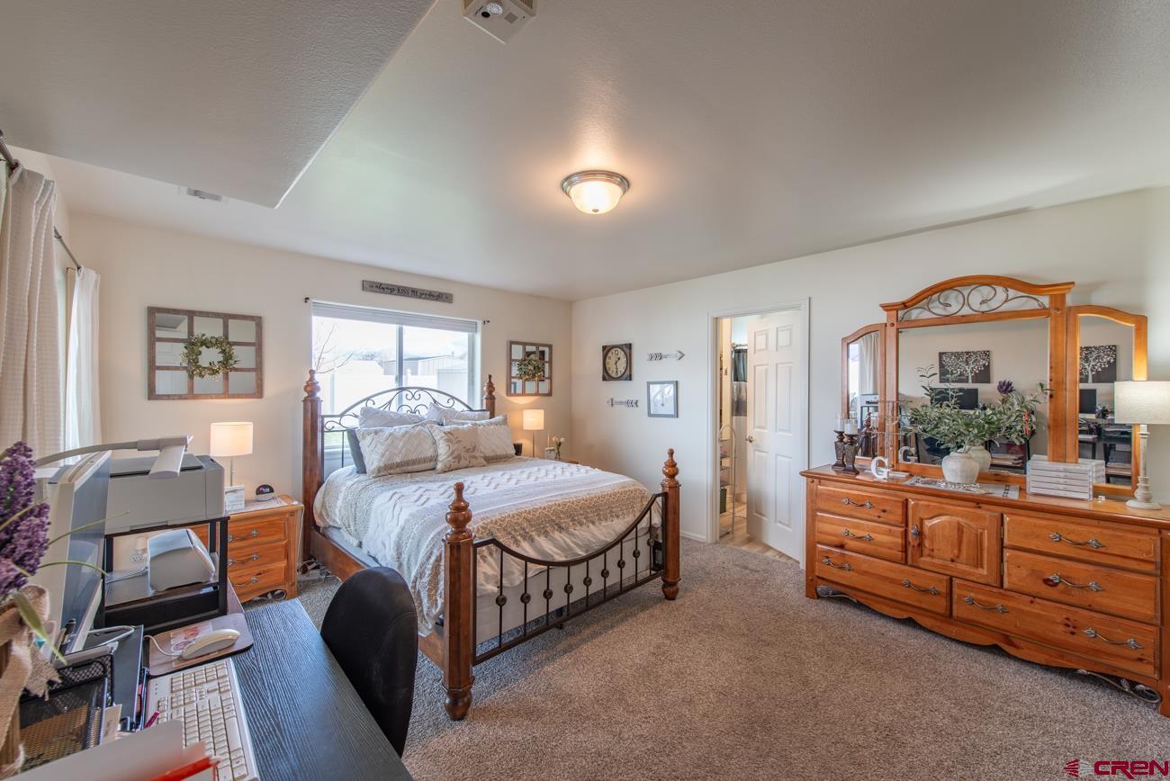 111 6675th Road Montrose, CO 81401 - Photo 23 of 40 a bedroom with a bed and a dresser