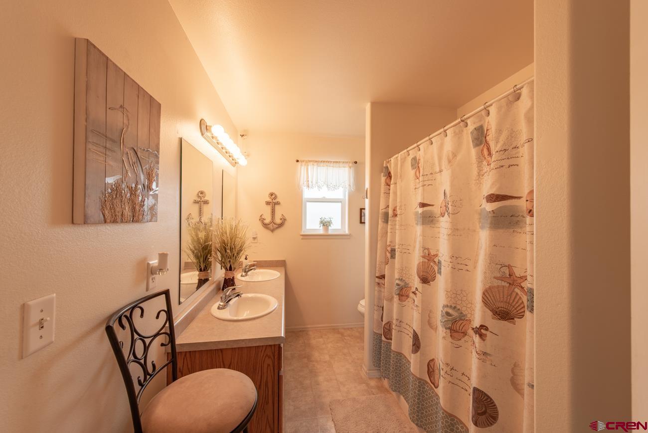 111 6675th Road Montrose, CO 81401 - Photo 31 of 40 a bathroom with a sink a toilet and shower curtain
