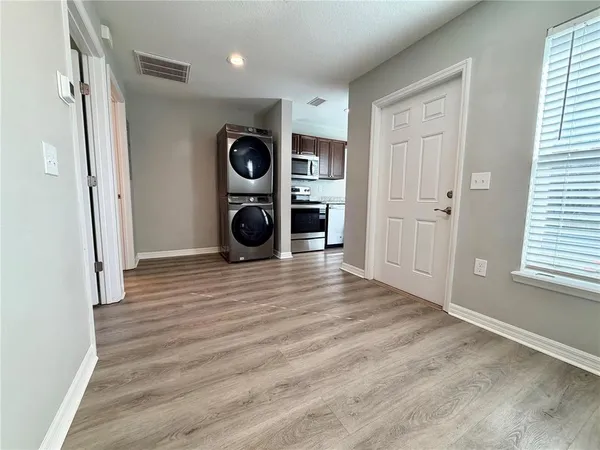 a view of a hallway with wooden floor and a window