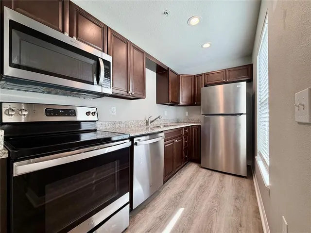 a kitchen with stainless steel appliances a stove microwave and refrigerator