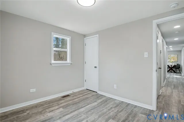 an empty room with wooden floor and a window