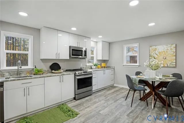 a kitchen with granite countertop white cabinets and white appliances