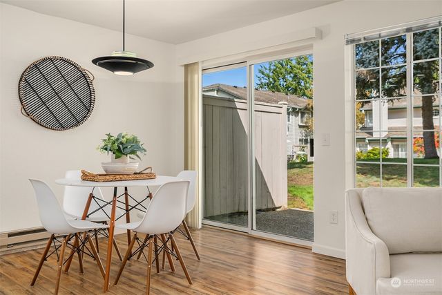 a dining room with furniture a window and wooden floor