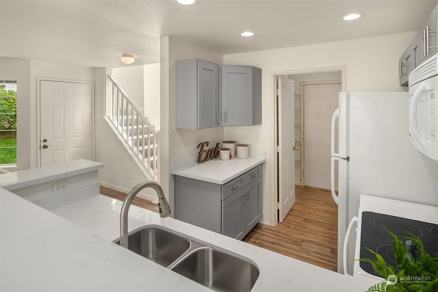 a kitchen with granite countertop a sink and a refrigerator