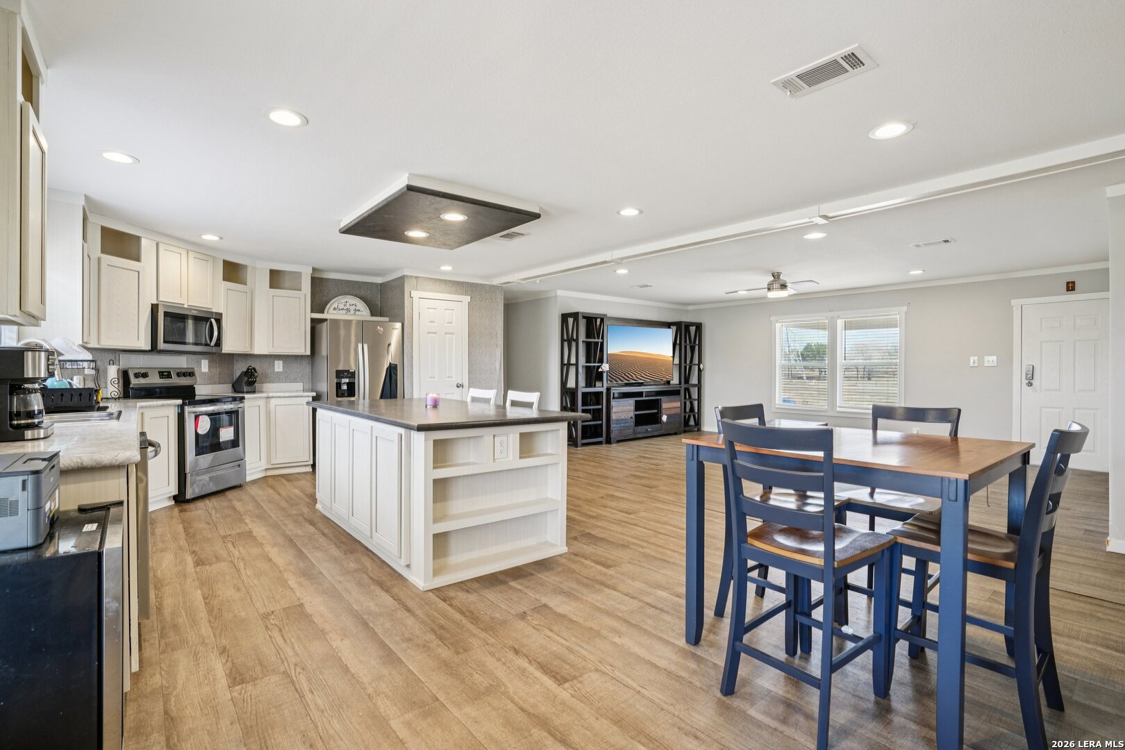 4045 Jakes Colony Road Seguin, TX 78155 - Photo 8 of 36 a kitchen with stainless steel appliances kitchen island granite countertop a table chairs sink and cabinets