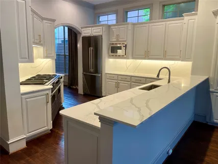 a kitchen with stainless steel appliances a refrigerator a sink a stove and a refrigerator