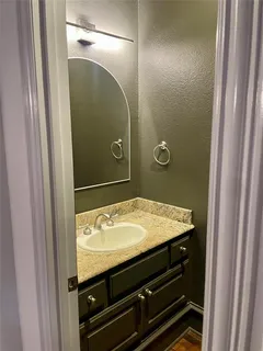 a bathroom with a granite countertop sink and mirror