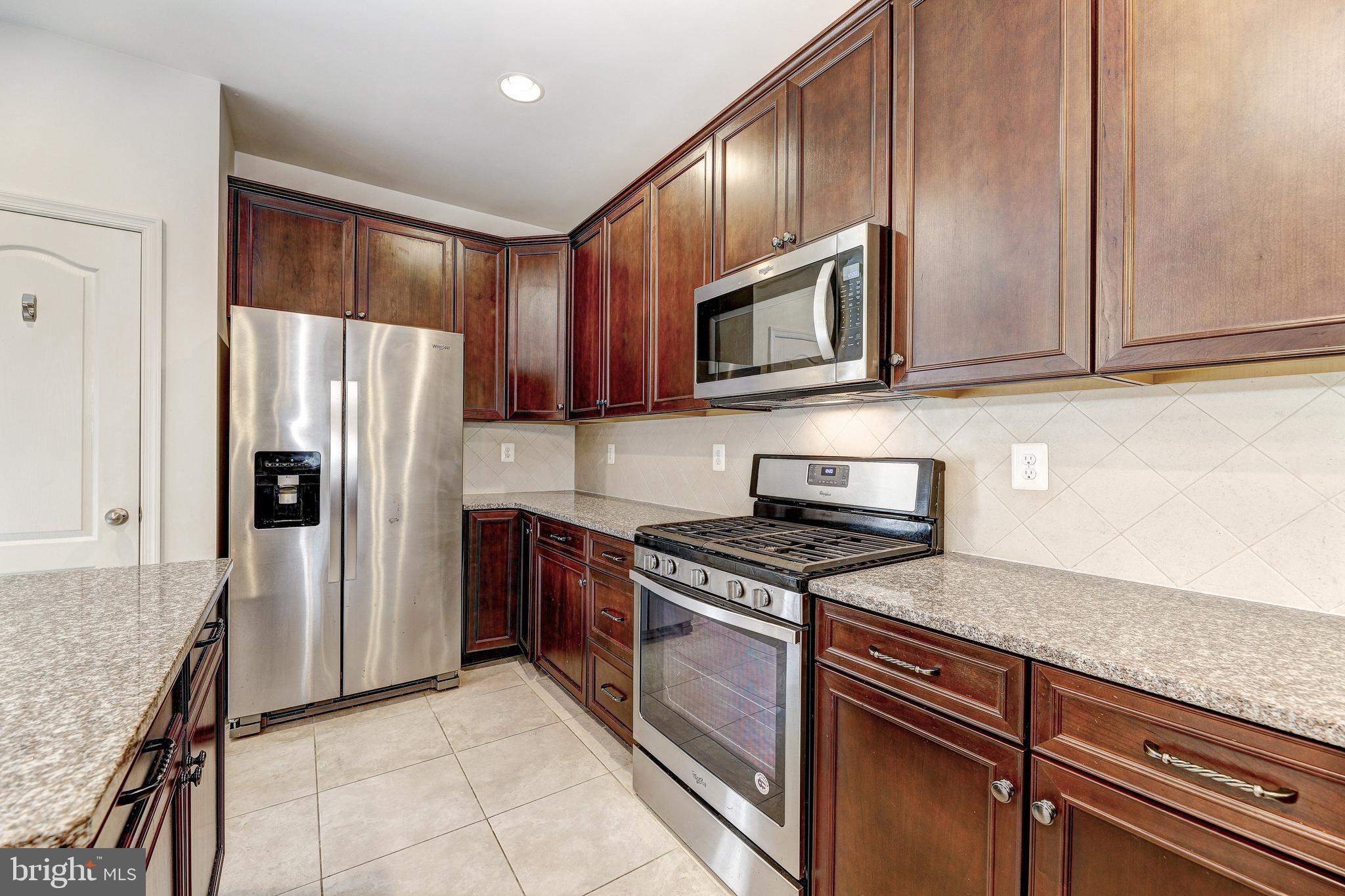 912 Winter Run Road Middle River, MD 21220 - Photo 15 of 55 a kitchen with granite countertop wooden cabinets stainless steel appliances and a counter space