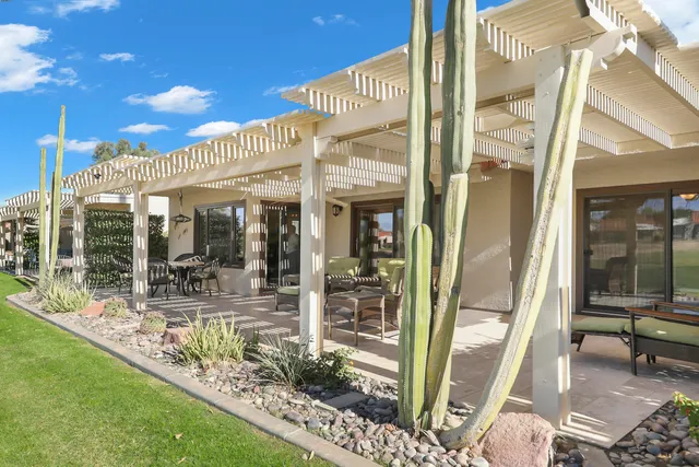 a view of a porch with chairs and floor to ceiling window