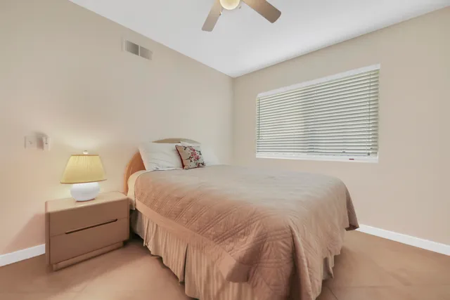 a bedroom with a bed and a ceiling fan