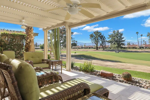 a view of a patio with lawn chairs floor to ceiling window and an outdoor space