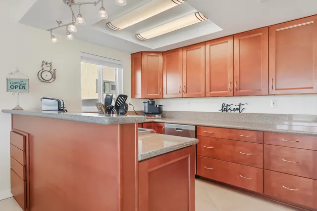 a kitchen with stainless steel appliances granite countertop a sink a stove cabinets and wooden floor