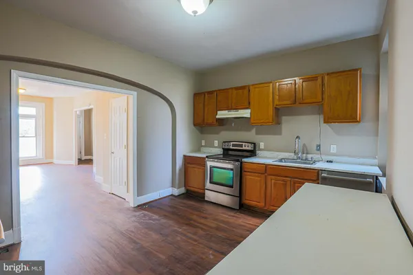 a kitchen with granite countertop white cabinets and stainless steel appliances
