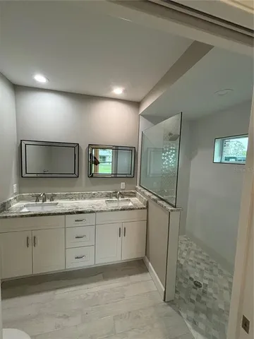 a bathroom with a granite countertop sink and a mirror