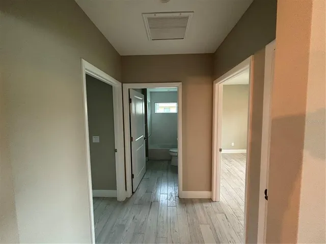 a view of a hallway with wooden floor