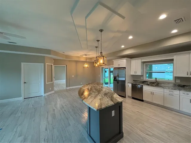 a kitchen with stainless steel appliances granite countertop a sink and a stove top oven
