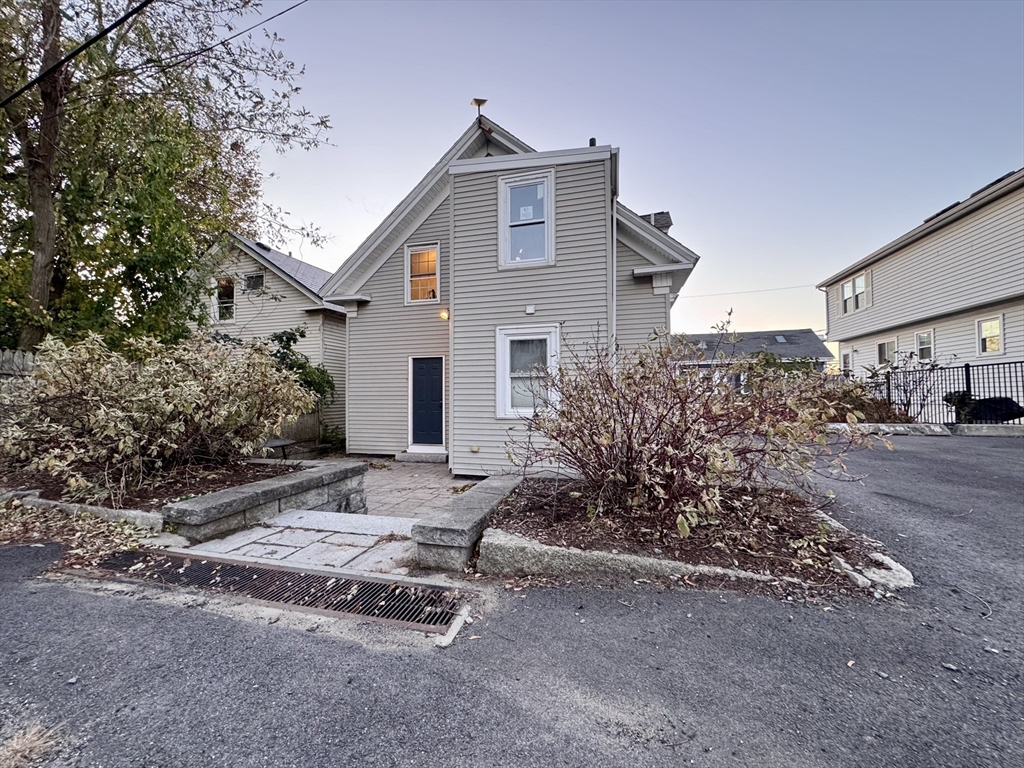 7 Hardy Street, Unit 1 Beverly, MA 01915 - Photo 19 of 24 a front view of a house with a yard and garage