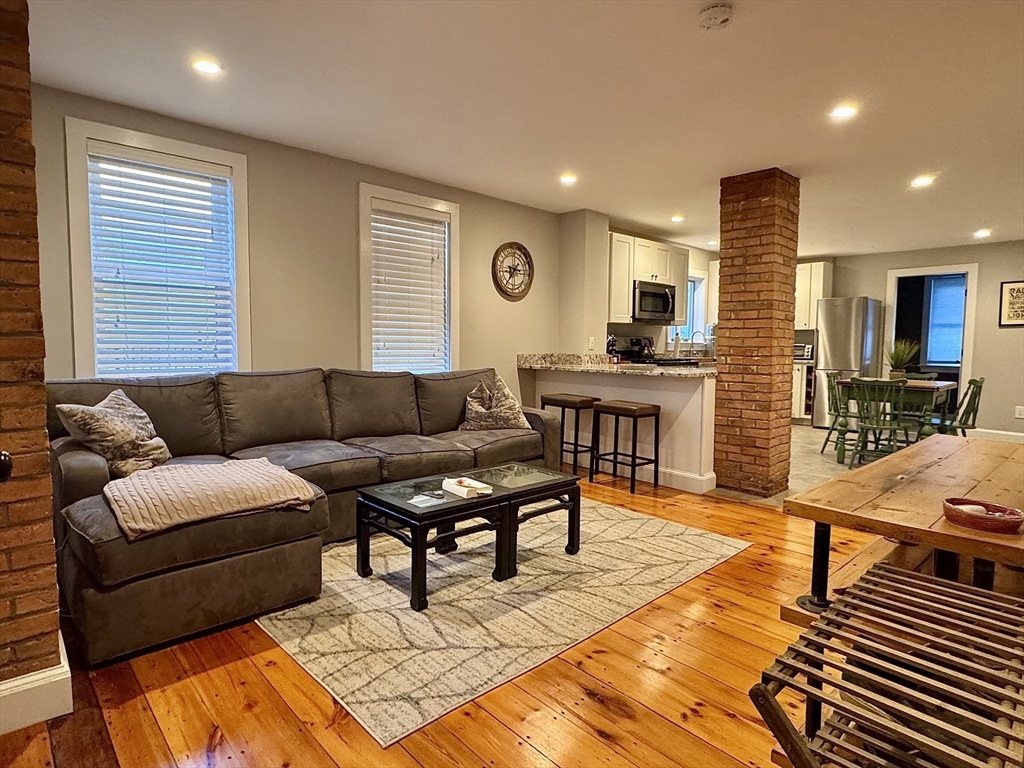 7 Hardy Street, Unit 1 Beverly, MA 01915 - Photo 2 of 24 a living room with furniture and a wooden floor