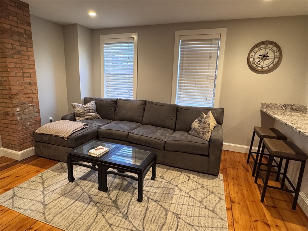 7 Hardy Street, Unit 1 Beverly, MA 01915 - Photo 3 of 24 a living room with furniture and a window