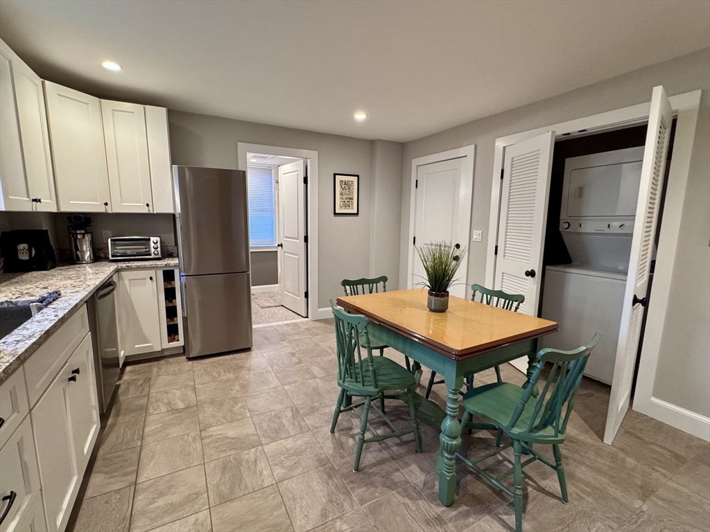 7 Hardy Street, Unit 1 Beverly, MA 01915 - Photo 6 of 24 a kitchen with stainless steel appliances a table and chairs
