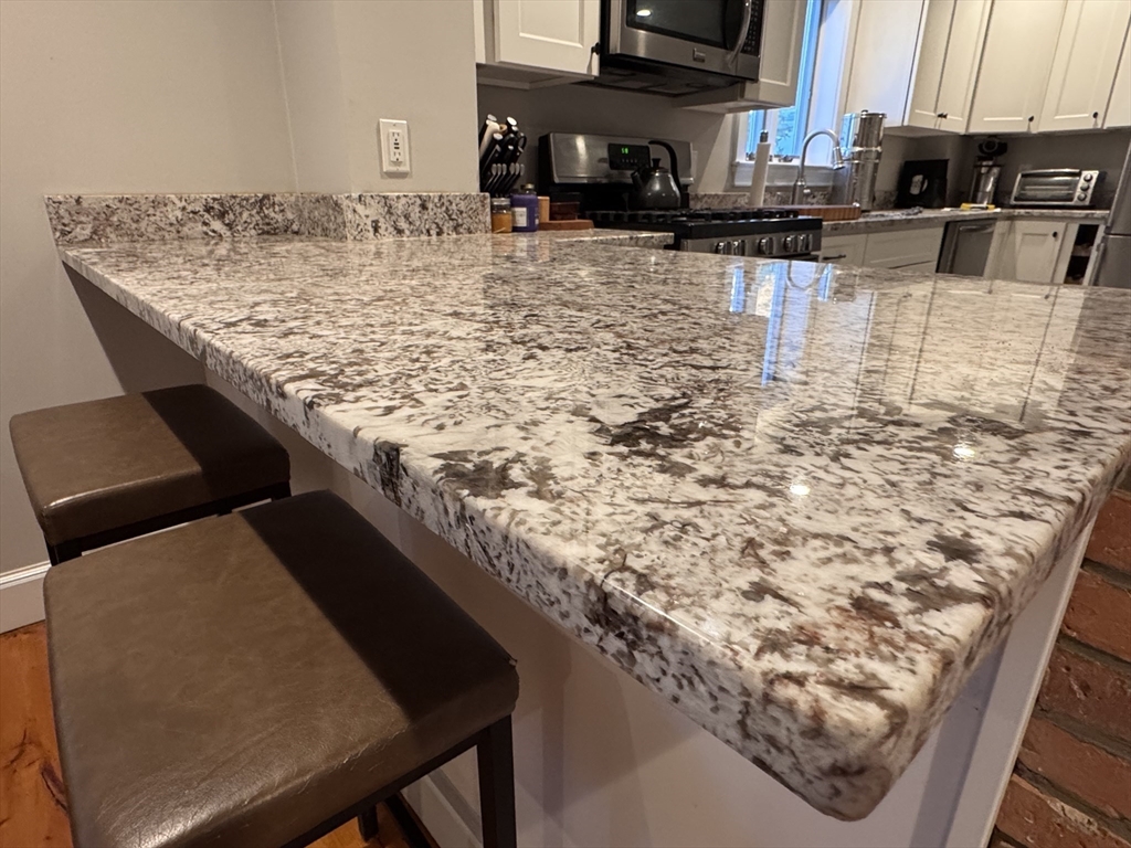 7 Hardy Street, Unit 1 Beverly, MA 01915 - Photo 8 of 24 a kitchen with table and chairs