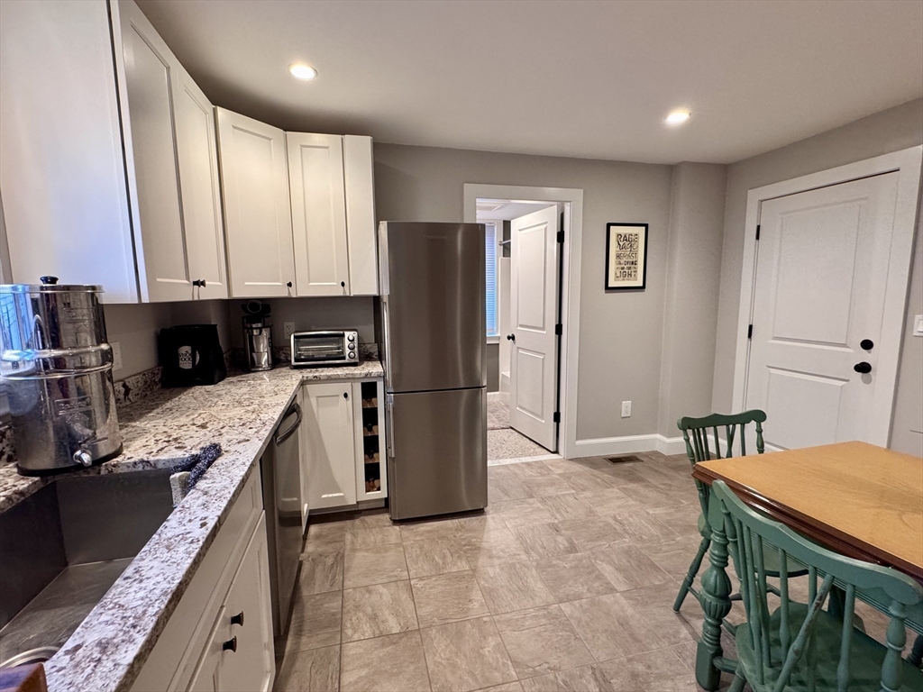 7 Hardy Street, Unit 1 Beverly, MA 01915 - Photo 9 of 24 a kitchen with stainless steel appliances granite countertop a refrigerator a stove and a refrigerator