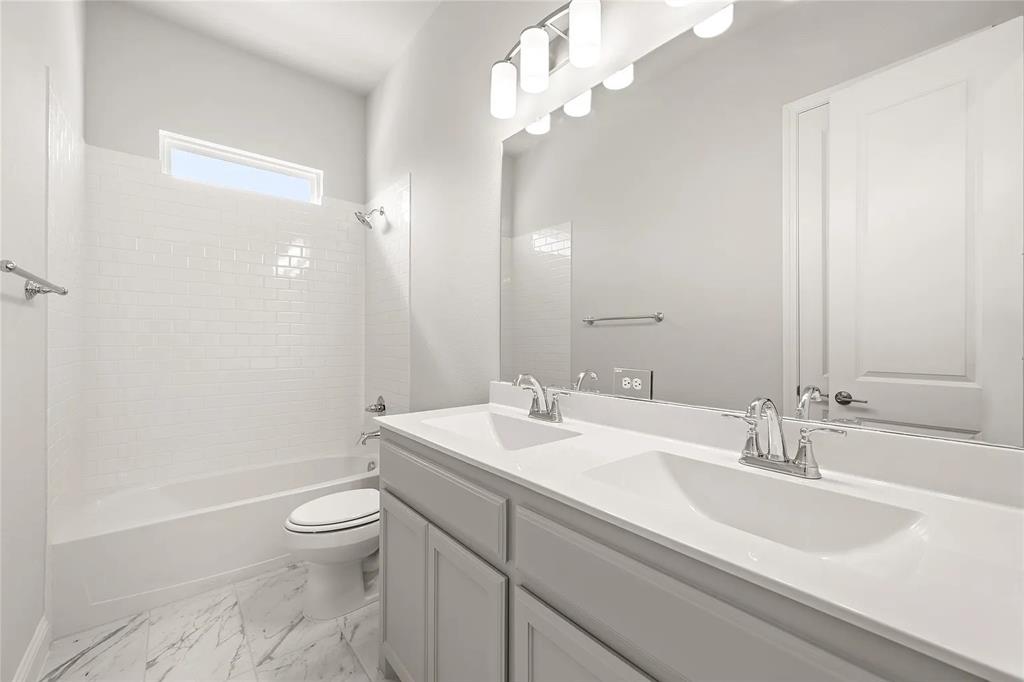 4021 Alpine Street Midlothian, TX 76065 - Photo 12 of 18 Bathroom featuring a dual vanity with integrated sinks, a chrome faucet, and a large mirror