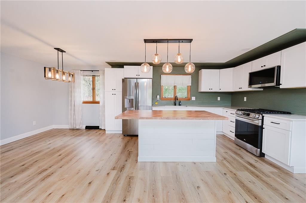 89 Marcoline Road Home, PA 15747 - Photo 4 of 47 a large kitchen with stainless steel appliances a large counter top a stove and a wooden floors