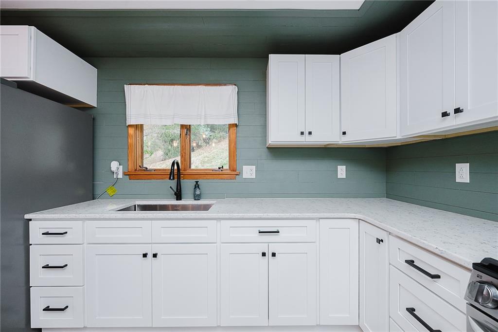89 Marcoline Road Home, PA 15747 - Photo 8 of 47 a kitchen with white cabinets and a window