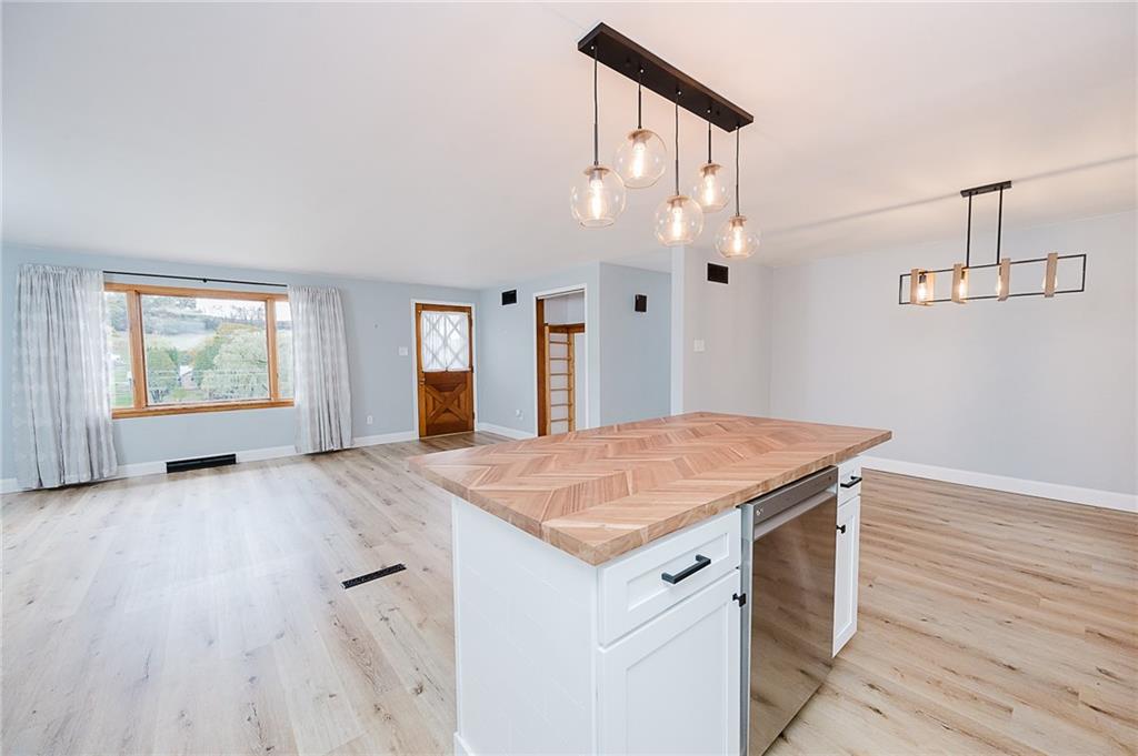 89 Marcoline Road Home, PA 15747 - Photo 9 of 47 a hall with kitchen island white cabinets and wooden floor