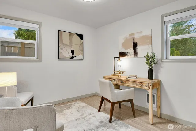 a view of a workspace with furniture and a window