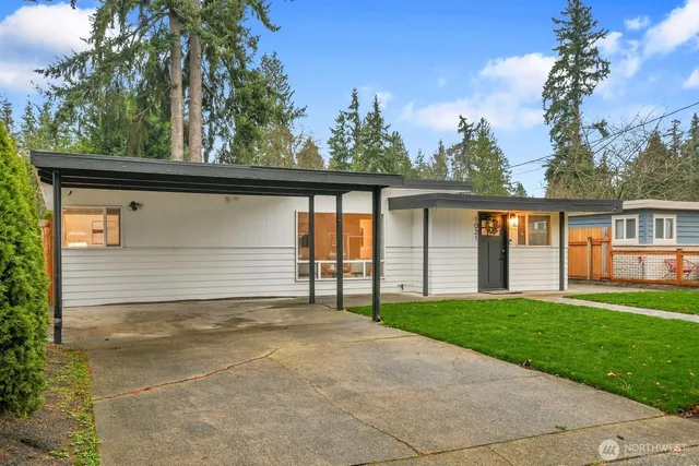 a view of house with backyard and a tree