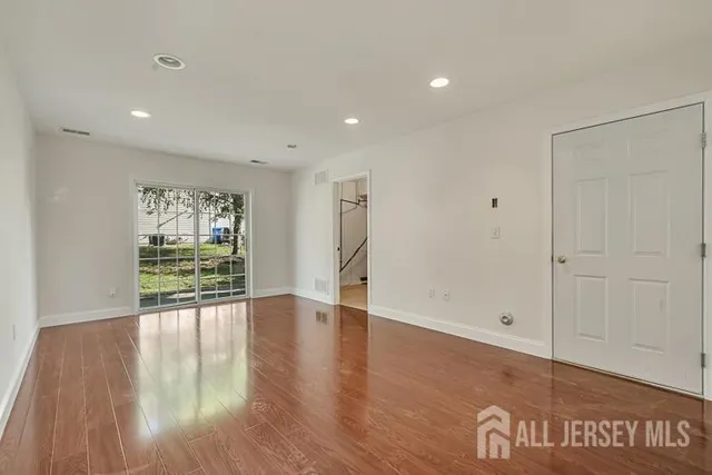 a view of an empty room with wooden floor