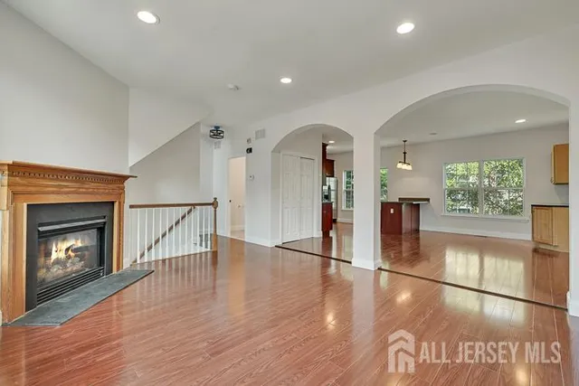 a view of a hallway with wooden floor a fireplace and a window