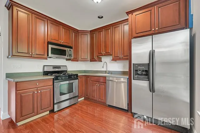 a kitchen with stainless steel appliances granite countertop a refrigerator stove top oven and sink