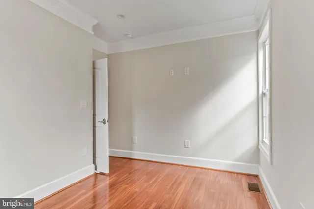 a view of an empty room with wooden floor