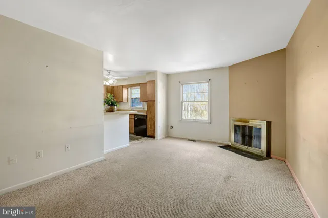 an empty room with a fireplace and windows