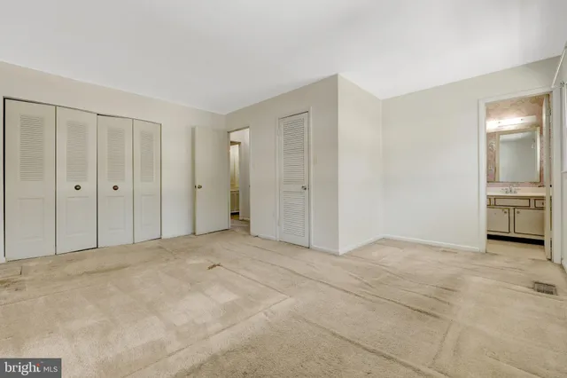 a view of an empty room with closet and a window