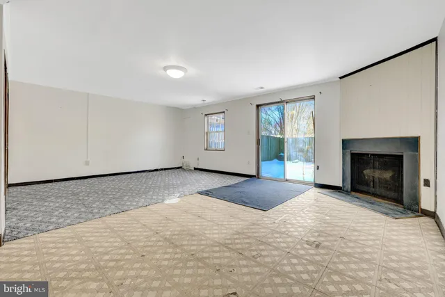 a view of empty room with windows and fireplace