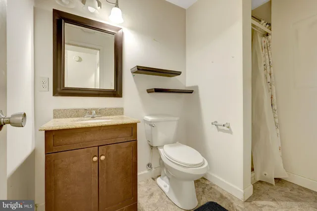 a bathroom with a toilet sink vanity and mirror