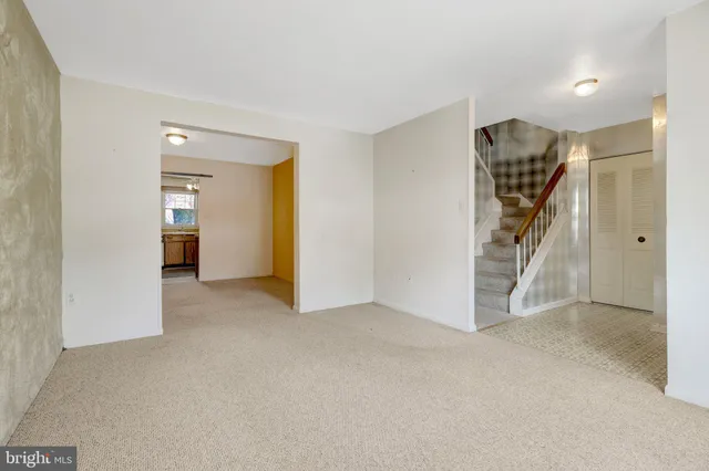 a view of an empty room with closet and stairs