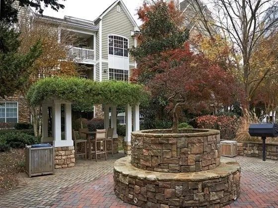 a view of a house with couches chair and fire pit