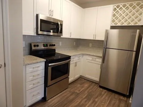 a kitchen with white cabinets and stainless steel appliances