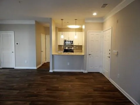 a view of a kitchen with wooden floor and a window